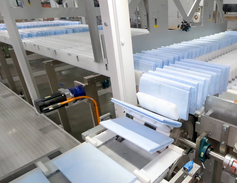 Healthcare cartons being loaded on an Aagard packaging line
